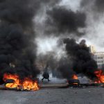Demonstrators block a road with burning tires during a protest in Beirut