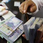 A man counts Lebanese pounds at a currency exchange shop in Beirut