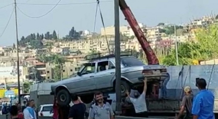 بالصور- علق في الزحمة بسبب قطع الطريق.. فاستنجد بالرافعة!